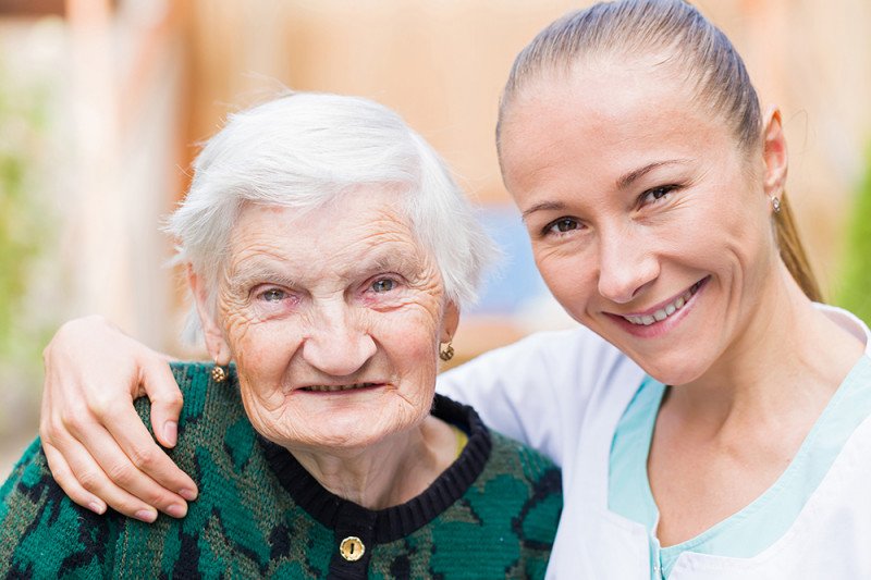 ältere Dame und Pflegerin lachen